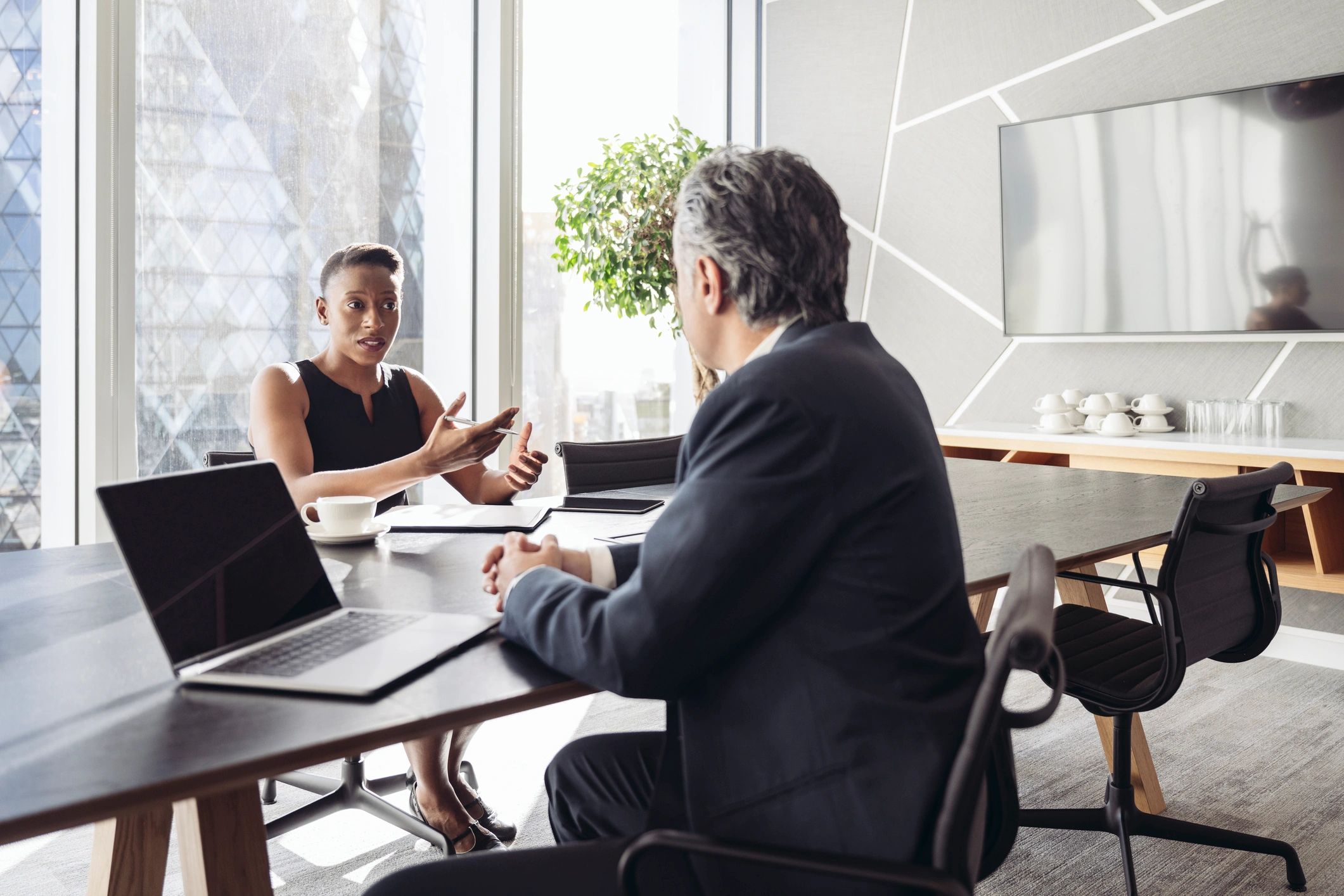 Cybersecurity consultants meeting with a client team in a modern boardroom